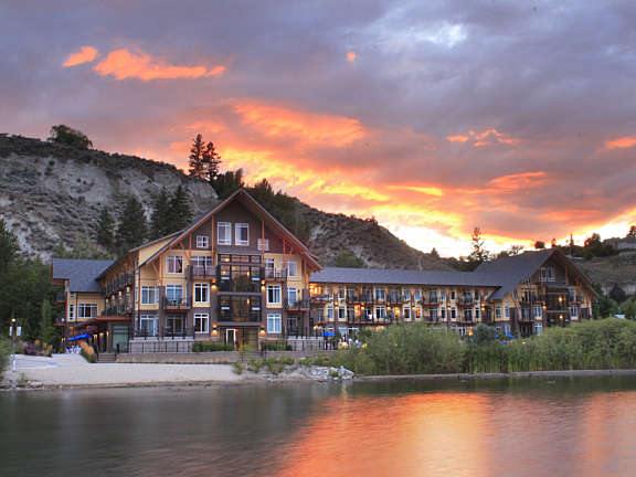 Sunset view of Summerland Waterfront Resort & Spa beside the lake with hillside in the background.
