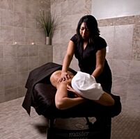 RMT giving a massage in a treatment room at iKhaya Day Spa