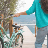 Guest with a bike looking out over the lake, showing the 'play' aspect of the resort.
