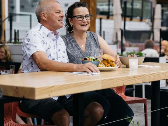 Couple enjoying a relaxed outdoor meal on the resort’s patio.