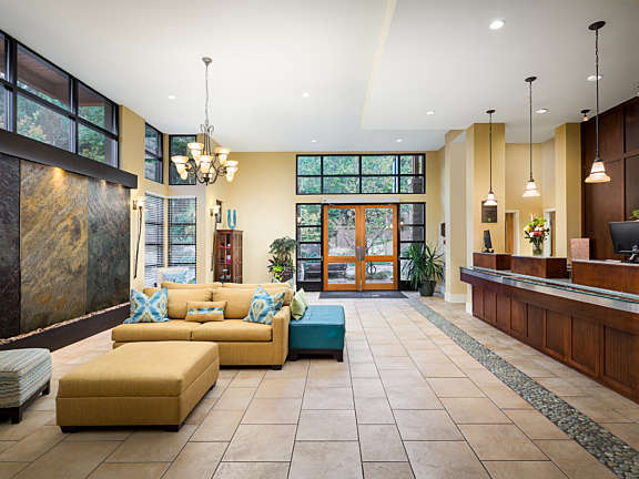 Interior view of a resort lobby with couches, reception desk, and tiled floors