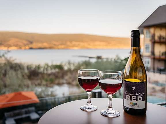 Wine bottle and two glasses on a lakeview balcony at Summerland Waterfront Resort & Spa.