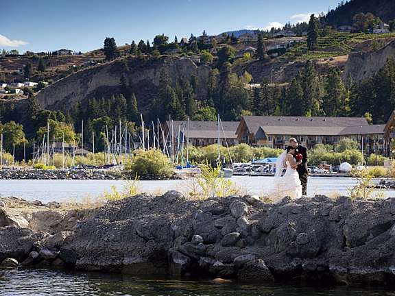 Wedding couple posing on the lakeside rocks at Summerland Waterfront Resort.