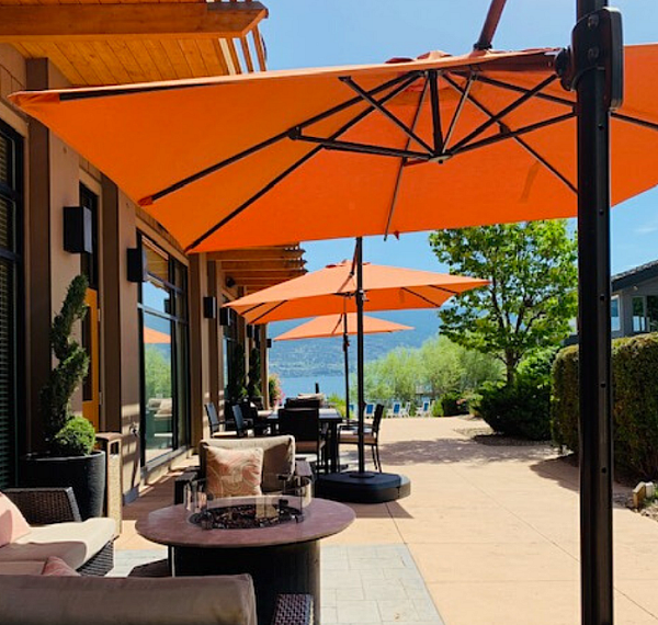 Resort beach with tables, seating, and umbrellas at Summerland Waterfront Resort & Spa
