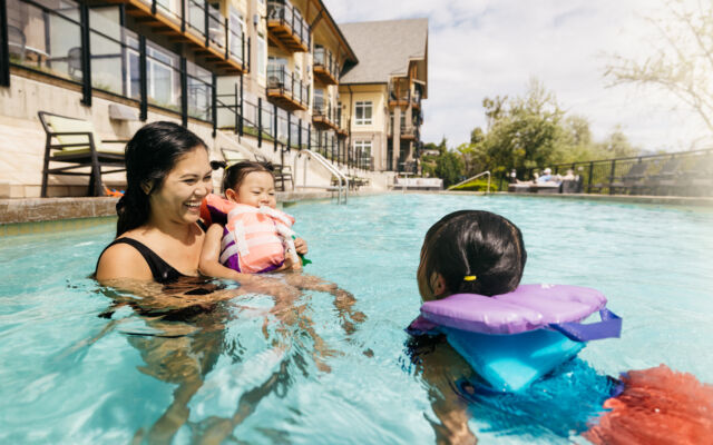 Family swimming together in the outdoor pool at Summerland Waterfront Resort & Spa.