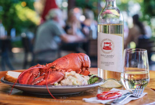 Lobster dinner next to bottle of white wine at Diry Laundry Vineyard