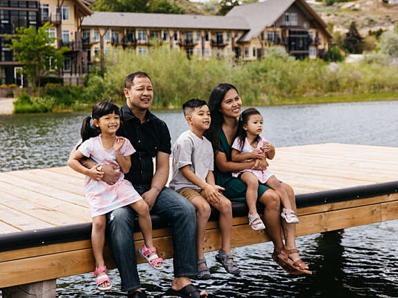 Family sitting on the dock on Okanagan Lake at Summerland Waterfront Resort & Spa