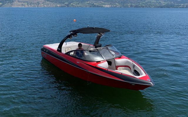 A guest driving red Malibu Wakesetter boat on Okanagan Lake near Summerland Waterfront Resort