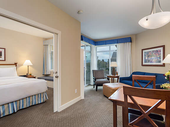 One Bedroom Suite at Summerland Waterfront Resort & Spa featuring bedroom, seating area, and dining table.