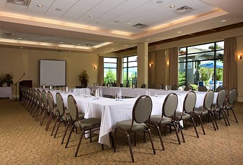 Waterfront Ballroom set in a U-shape layout with tables, chairs, podium, and projector screen at Summerland Waterfront Resort & Spa.